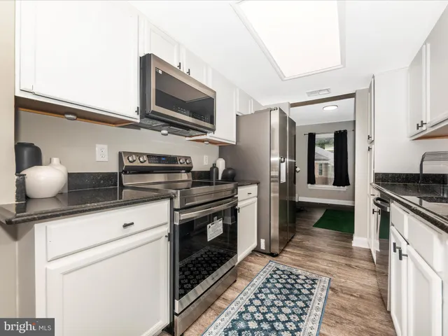 a kitchen with stainless steel appliances granite countertop a sink and a stove