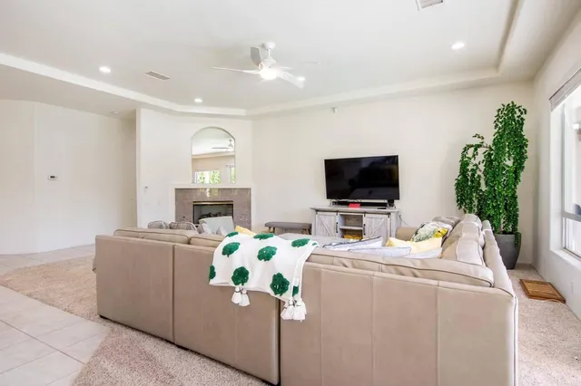 a living room with furniture a flat screen tv and a fireplace
