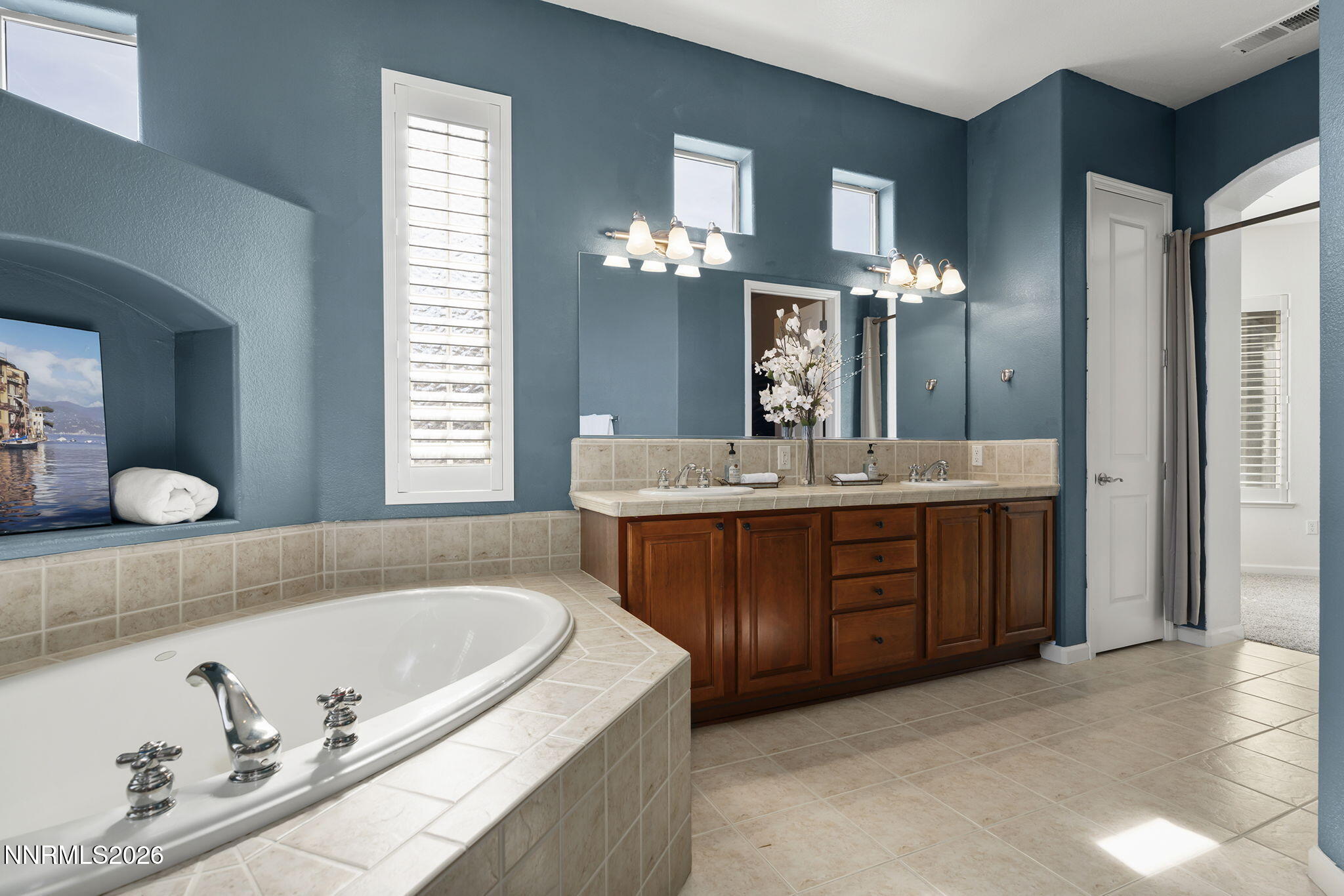 9900 Wilbur May Parkway, Unit 304 Reno, NV 89521 - Photo 21 of 47 a bathroom with a granite countertop tub a double vanity sink and a large mirror