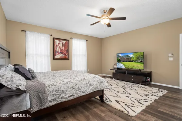 a bedroom with a bed window and a flat screen tv