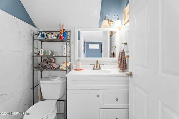 a bathroom with a toilet sink and mirror