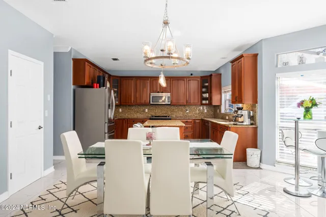 a view of kitchen with refrigerator stove dining table and chairs