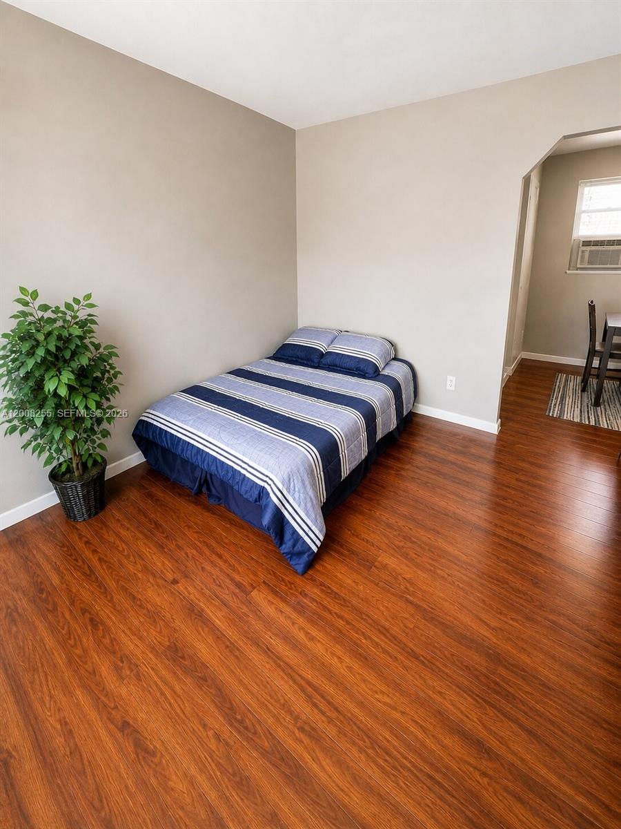 375 Southwest 19th Avenue, Unit 4 Miami, FL 33135 - Photo 26 of 30 a bedroom with a bed and a wooden floor