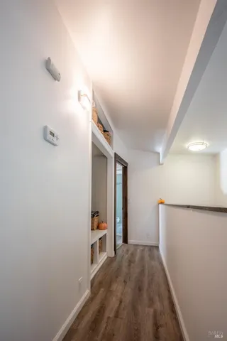 a view of hallway with stairs and wooden floor