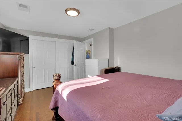 a bedroom with a bed dresser and a flat tv screen