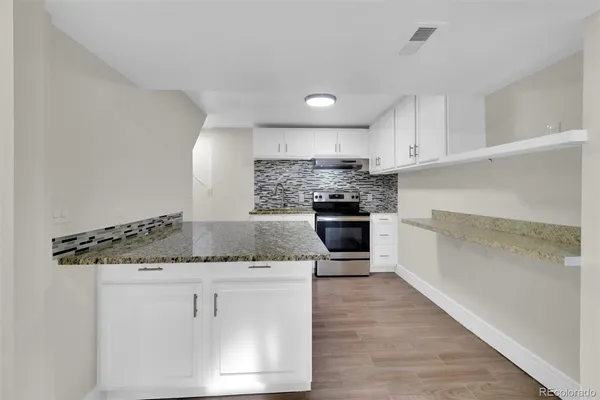 a kitchen with stainless steel appliances granite countertop a sink and a stove