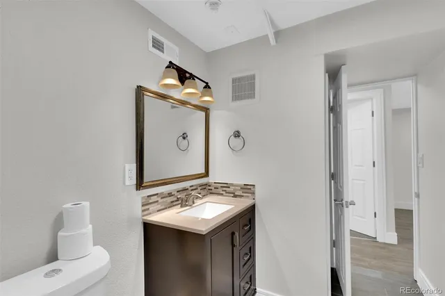 a bathroom with a sink and mirror with toilet