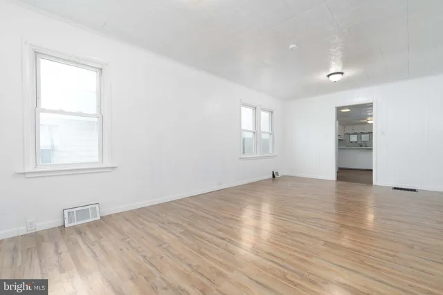a view of empty room with wooden floor