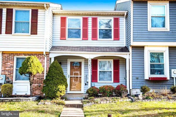 front view of a brick house with a yard