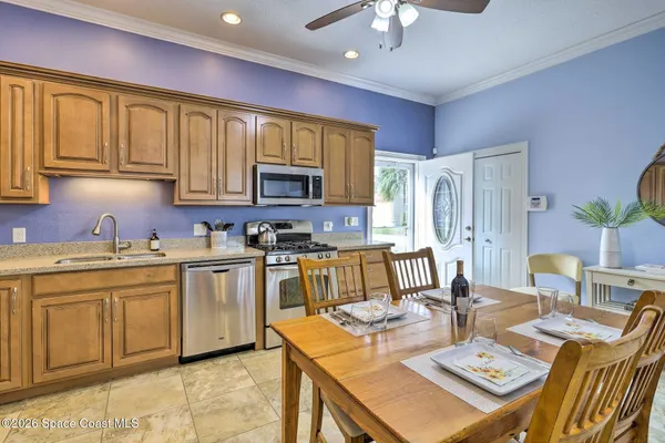 a open kitchen with stainless steel appliances granite countertop a stove a sink a dining table and chairs