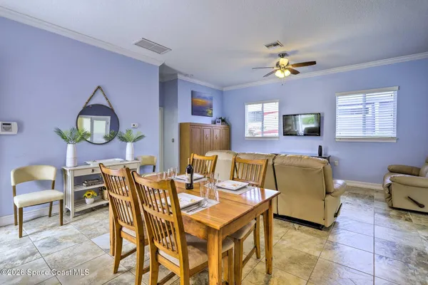 a living room with furniture a chandelier and a dining table