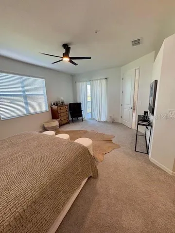 a spacious bedroom with a bed and a chandelier