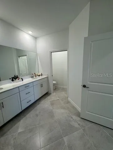 a spacious bathroom with a double vanity sink a mirror and a bathtub