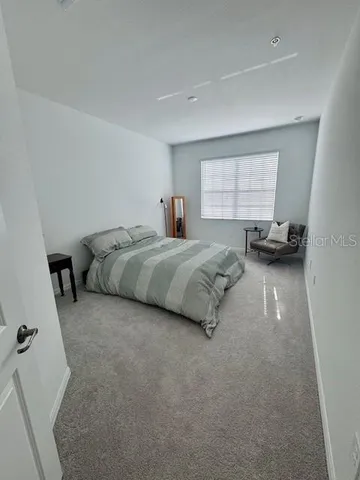 a spacious bedroom with a bed and a window