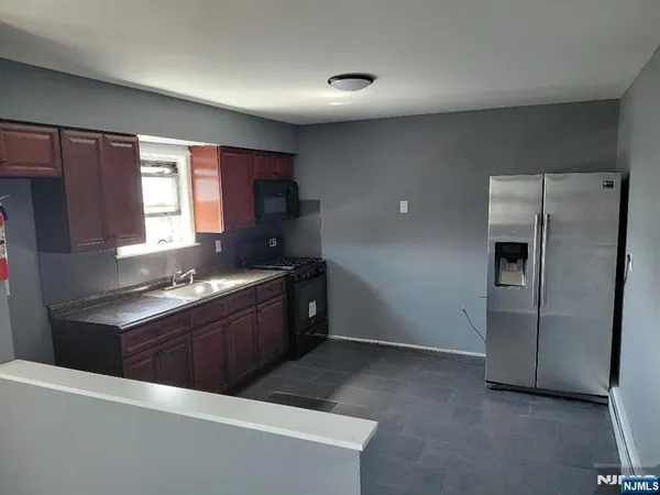 a kitchen with stainless steel appliances granite countertop a refrigerator stove and sink