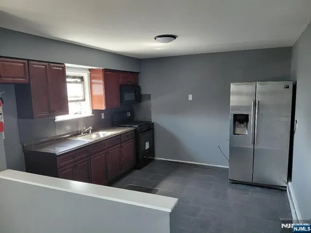 a kitchen with stainless steel appliances granite countertop a refrigerator stove and sink