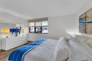 a bedroom with a large bed and a painting on the wall