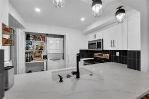 a view of living room kitchen with stainless steel appliances cabinets