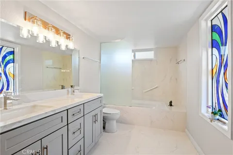 a bathroom with a granite countertop sink toilet and shower