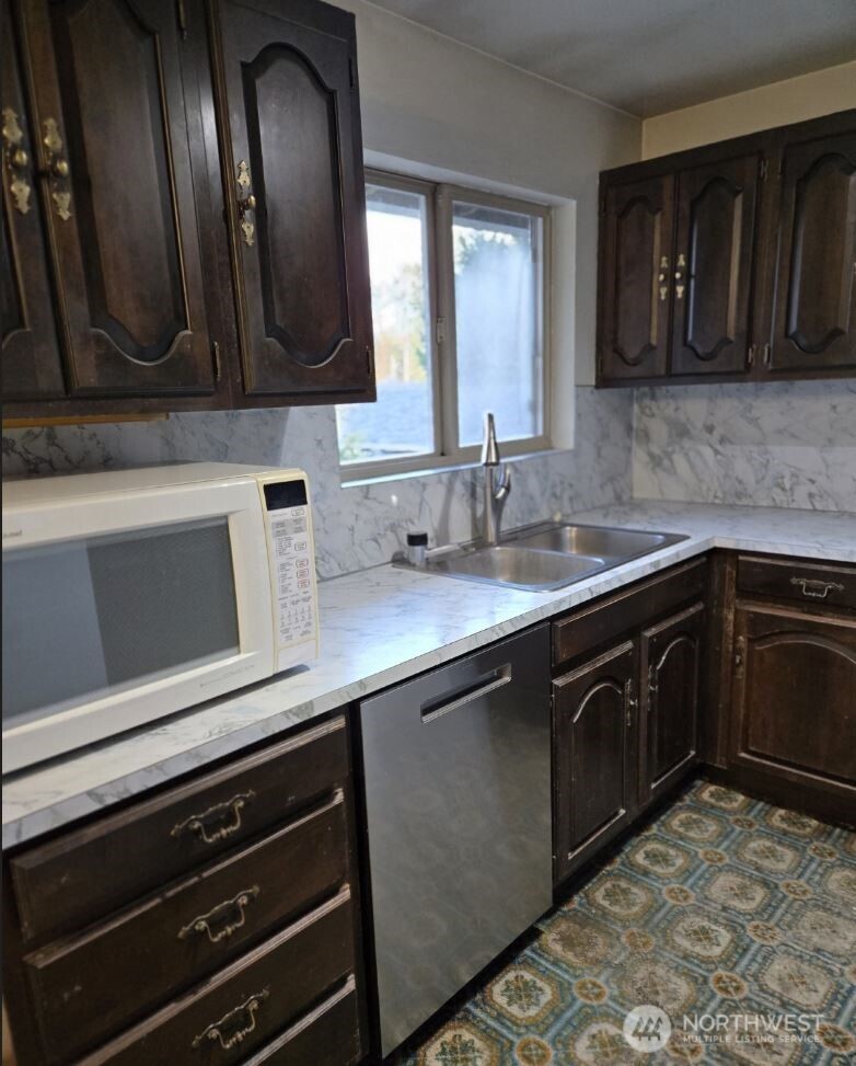 4316 Northeast 10th Street Renton, WA 98059 - Photo 6 of 25 a kitchen with stainless steel appliances granite countertop a sink stove and microwave