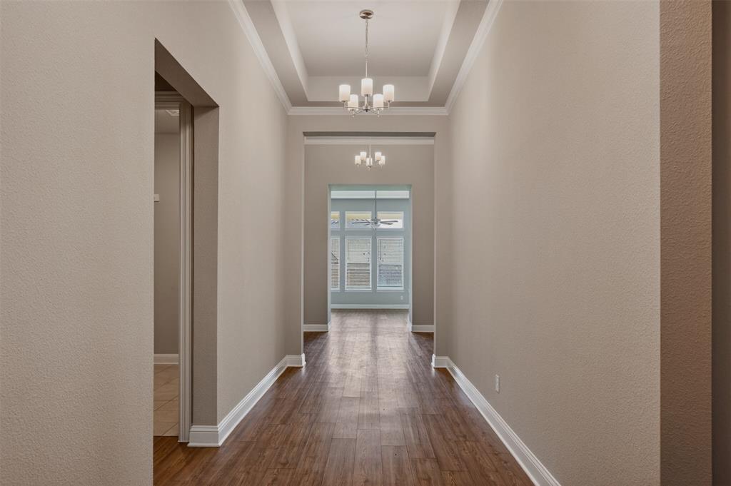 16812 Bitterroot Road Justin, TX 76247 - Photo 3 of 27 a view of a hallway with wooden floor and chandelier