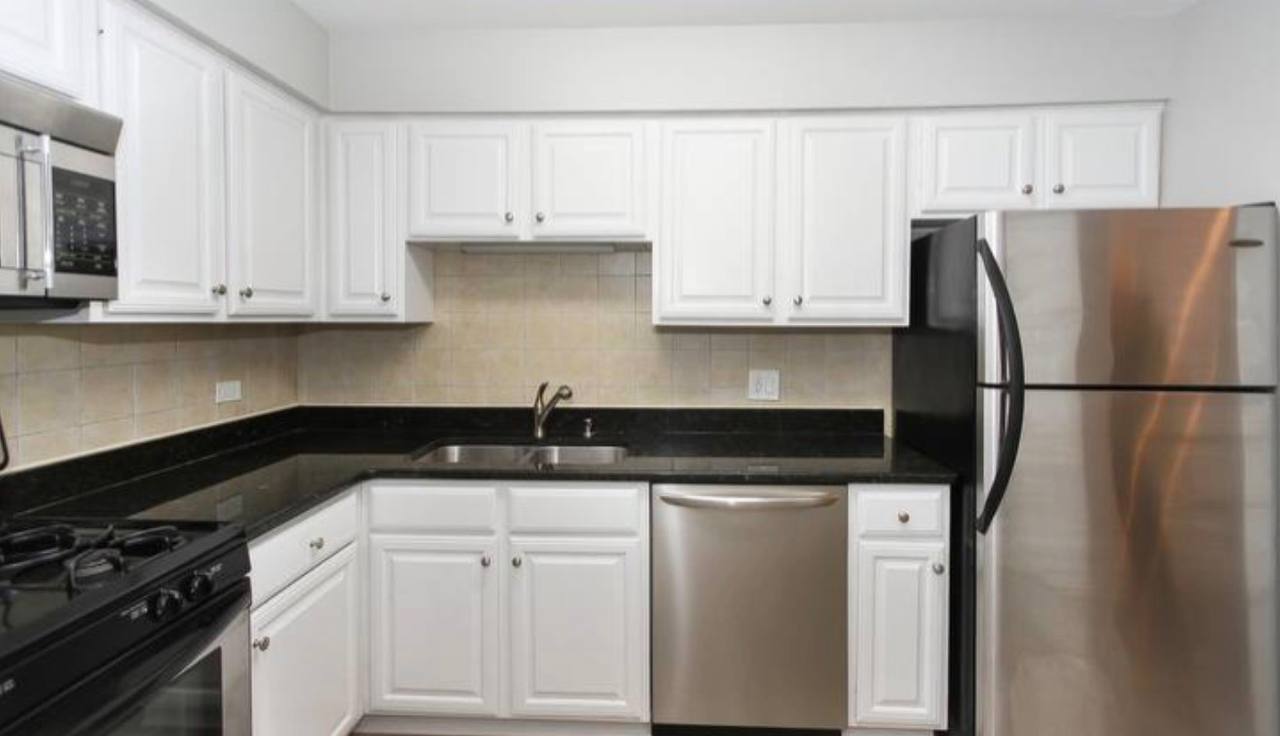677 South River Road, Unit 2H Des Plaines, IL 60016 - Photo 3 of 15 a kitchen with granite countertop a refrigerator sink and cabinets
