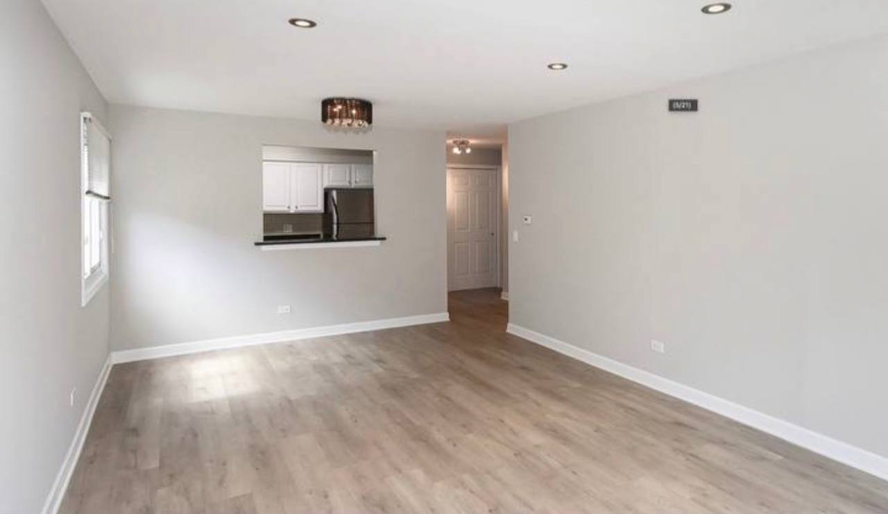 677 South River Road, Unit 2H Des Plaines, IL 60016 - Photo 6 of 15 a view of a livingroom with wooden floor and a window