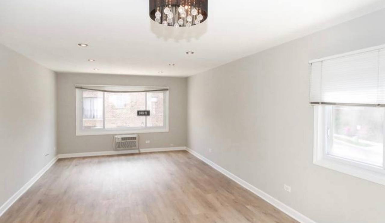 677 South River Road, Unit 2H Des Plaines, IL 60016 - Photo 7 of 15 an empty room with wooden floor and windows