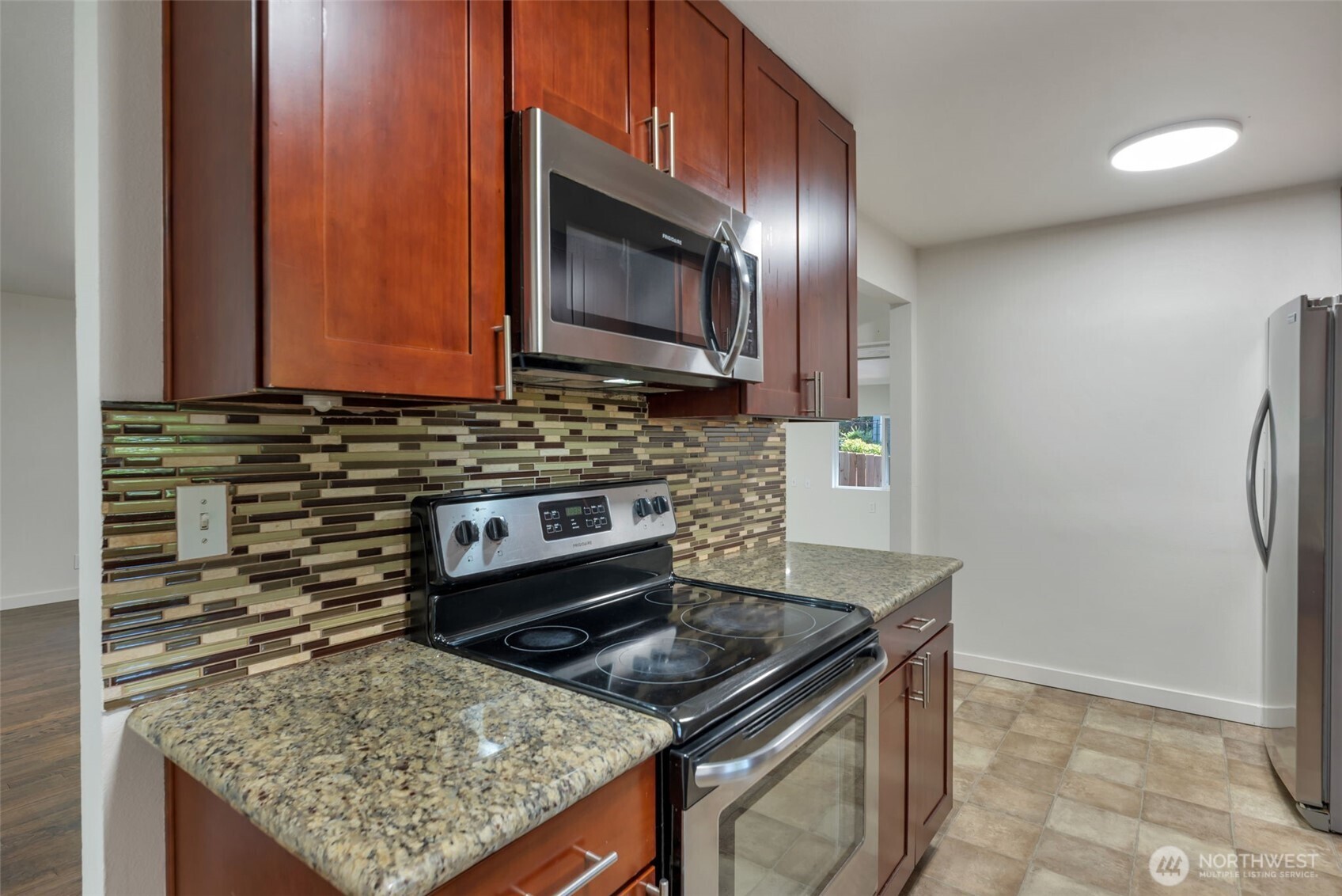 11229 29th Avenue Southwest Seattle, WA 98146 - Photo 8 of 28 a kitchen with stainless steel appliances granite countertop a stove microwave and refrigerator