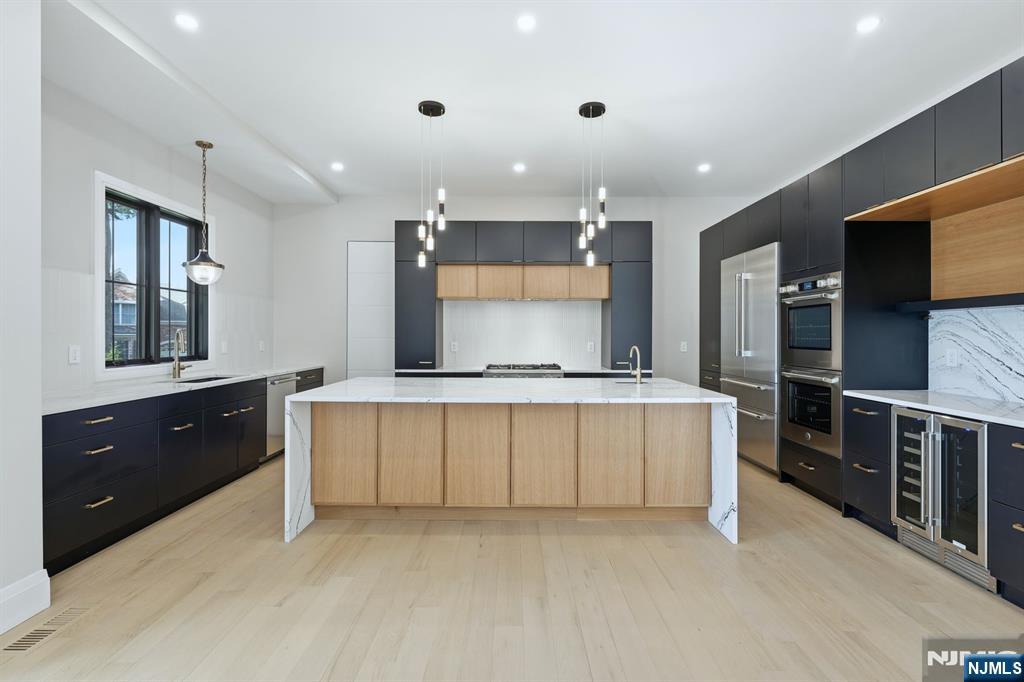 121 Engle Street Cresskill, NJ 07626 - Photo 14 of 50 a large kitchen with stainless steel appliances a large counter top a stove and a refrigerator