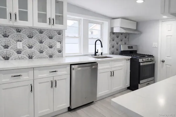 a kitchen with white cabinets and appliances