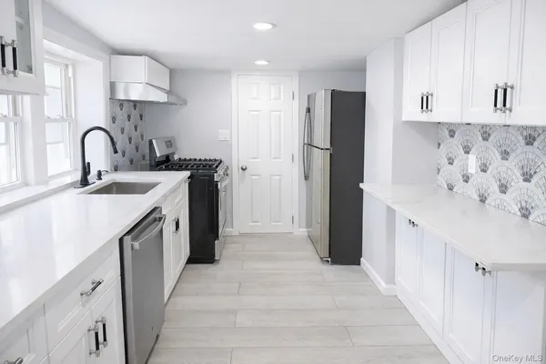 a kitchen with stainless steel appliances granite countertop a refrigerator and a sink