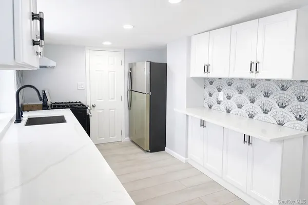a kitchen with a refrigerator sink and cabinets