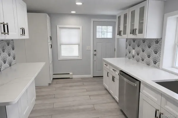 a kitchen with granite countertop a sink stove and cabinets