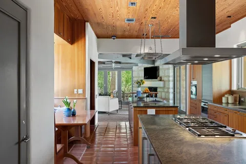 a kitchen with stainless steel appliances kitchen island granite countertop a stove and a view of living room