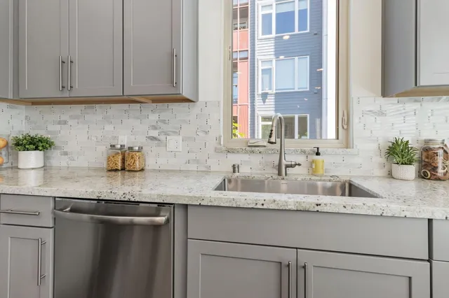 a kitchen with granite countertop a sink and cabinets