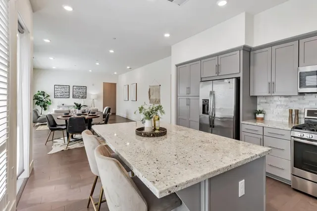 a kitchen with granite countertop kitchen island stainless steel appliances a table and chairs