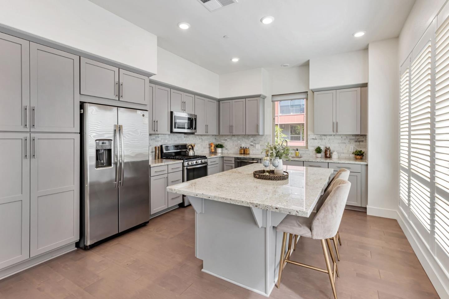 390 Riesling Avenue, Unit 30 Milpitas, CA 95035 - Photo 16 of 37 a kitchen with stainless steel appliances granite countertop a refrigerator a sink a stove a dining table and chairs