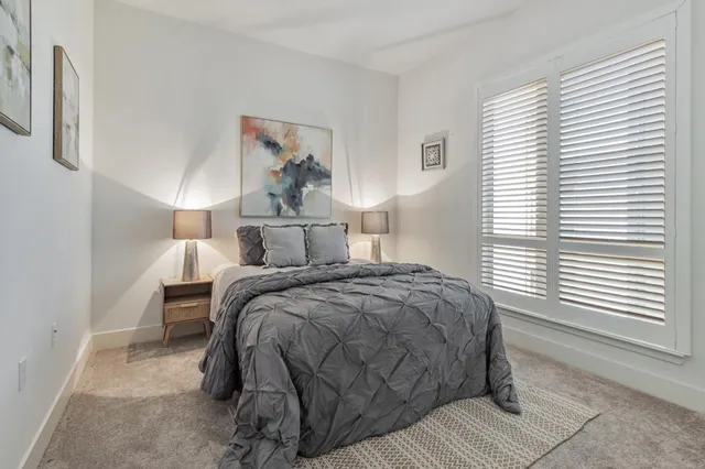 a view of a bedroom with a bed and a window