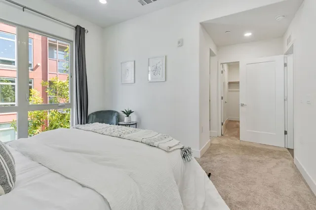 a bedroom with a bed and a couch next to a window