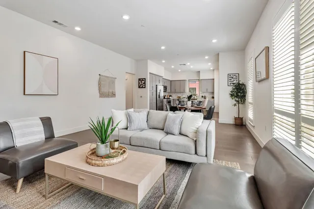 a living room with furniture kitchen and a large window