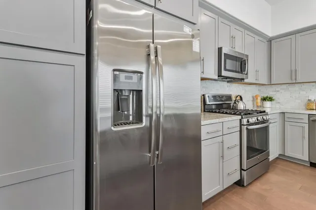 a kitchen with stainless steel appliances a refrigerator sink and microwave
