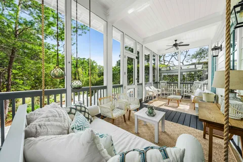 a view of a patio with couches chairs potted plants and floor to ceiling window