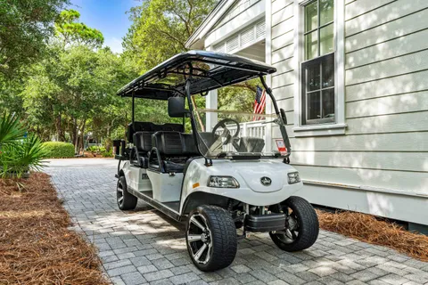 a dining room with wooden floor a chandelier a wooden table and chairs