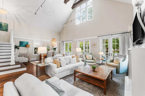 a kitchen with stainless steel appliances granite countertop a refrigerator a sink dishwasher a dining table and chairs with wooden floor