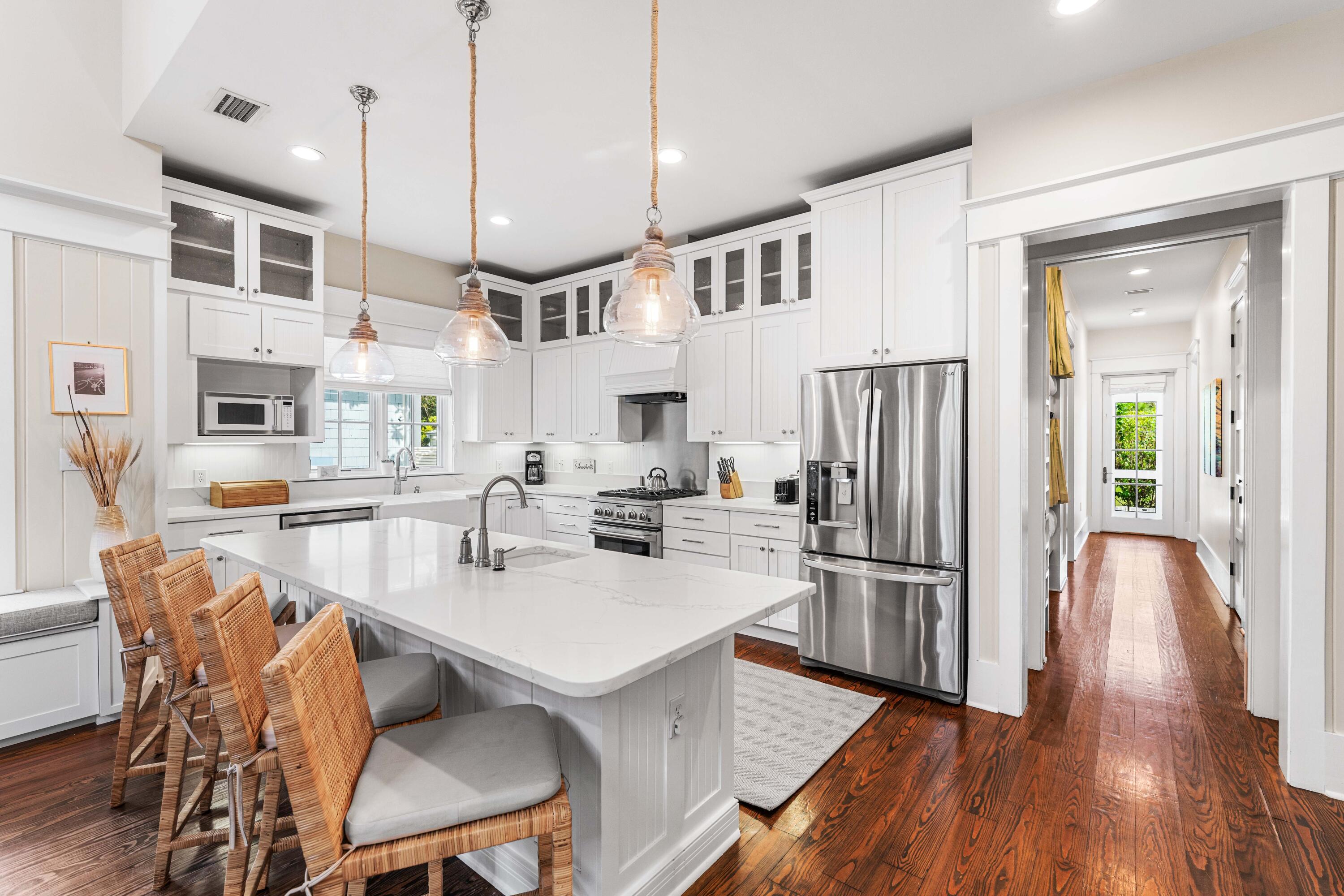 406 Red Cedar Way Santa Rosa Beach, FL 32459 - Photo 34 of 60 a kitchen with stainless steel appliances granite countertop a refrigerator a sink dishwasher a dining table and chairs with wooden floor