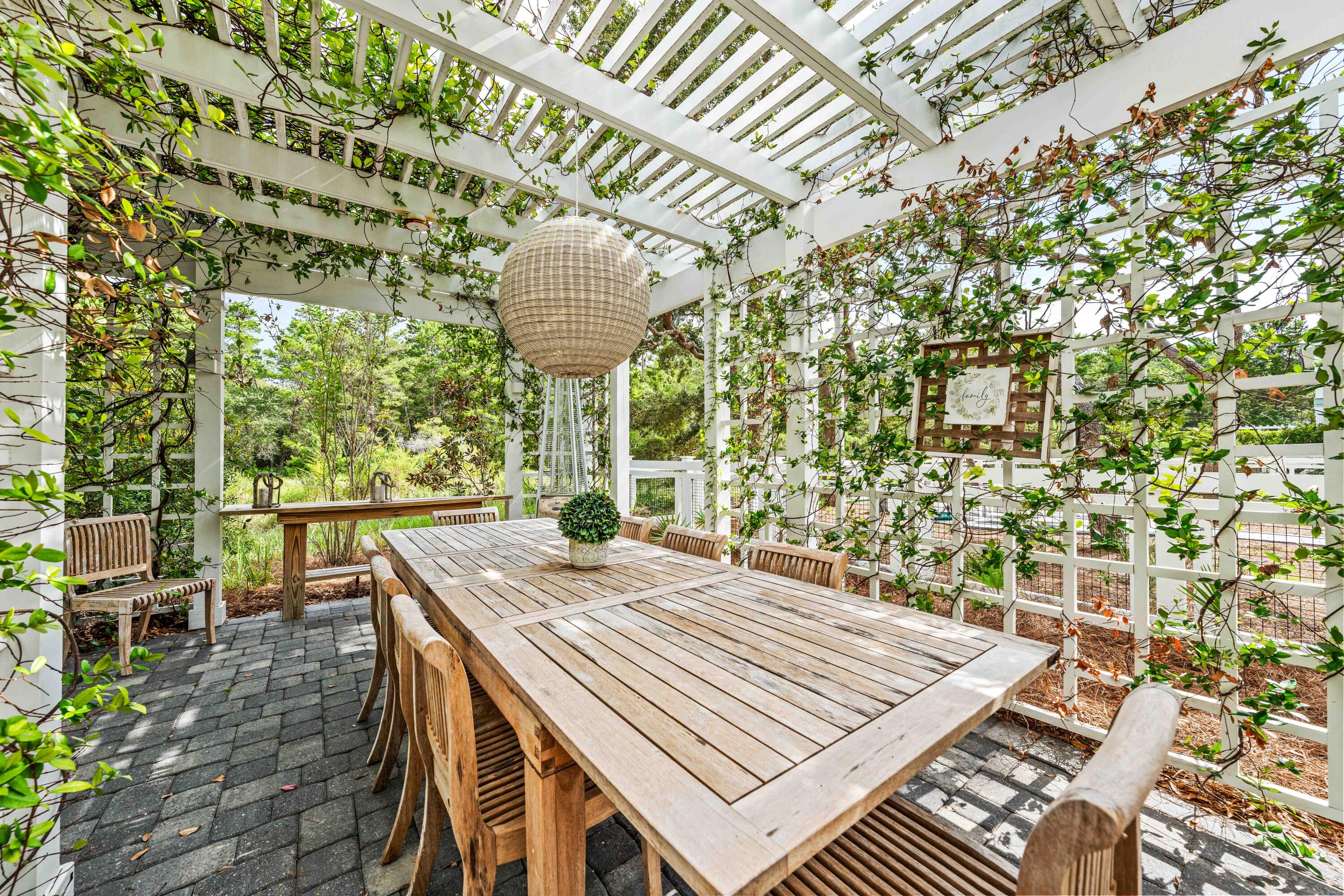 406 Red Cedar Way Santa Rosa Beach, FL 32459 - Photo 7 of 60 a view of a patio with table and chairs with wooden floor and plants