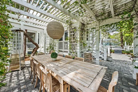 a view of a patio with a dining table and chairs with wooden floor and fence