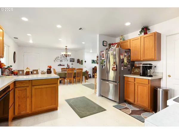 a kitchen with stainless steel appliances kitchen island granite countertop a refrigerator a stove a sink dishwasher and a oven with cabinets