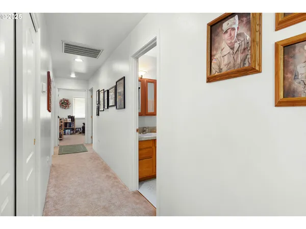 a view of a hallway with wooden floor and dining room